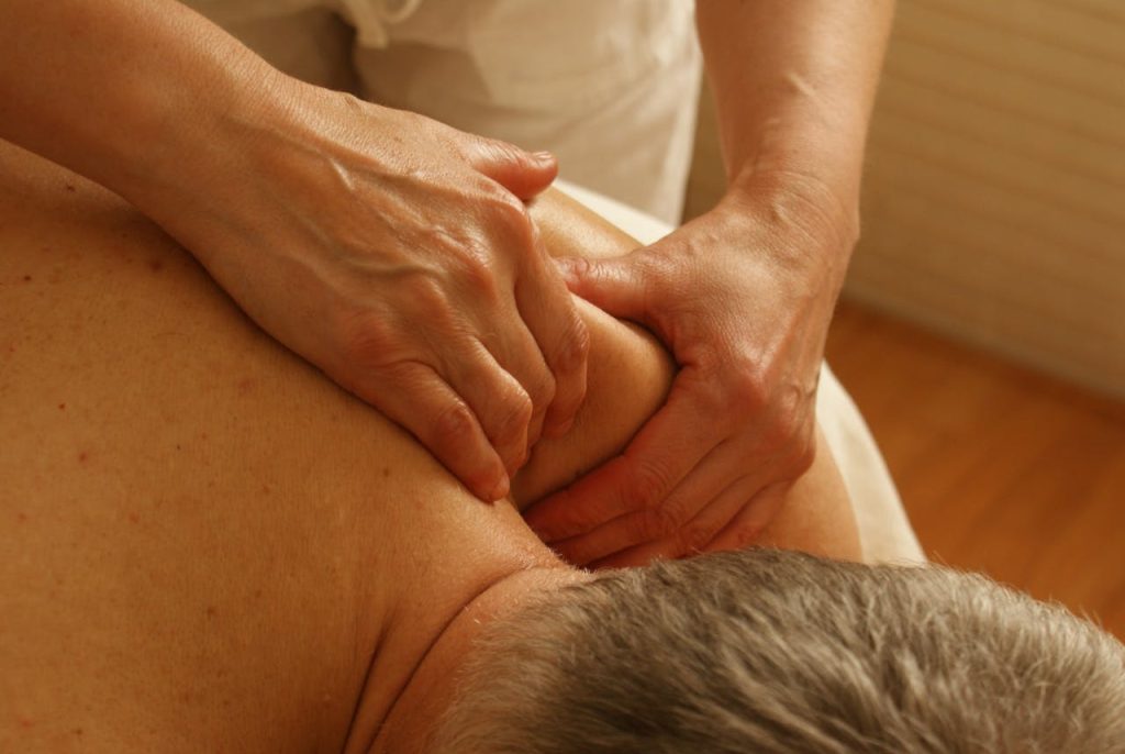 person-massaging-man-s-shoulder-275768 Close-up of a therapist giving a relaxing shoulder massage, enhancing wellness and stress relief.